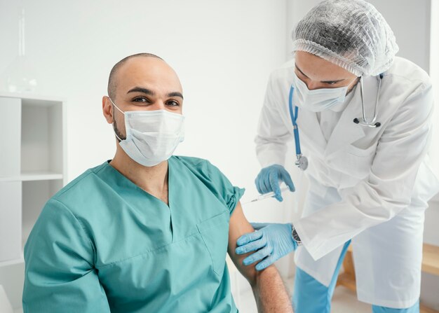 Doctor vacunando a un paciente en la clínica.