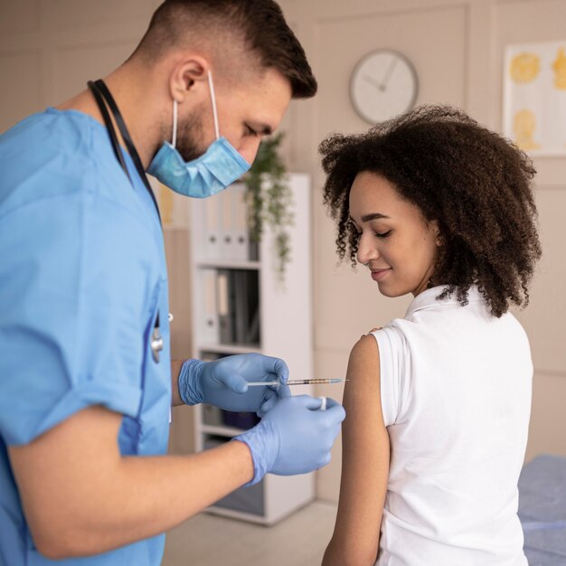 Doctor vacunar a un paciente en una clínica