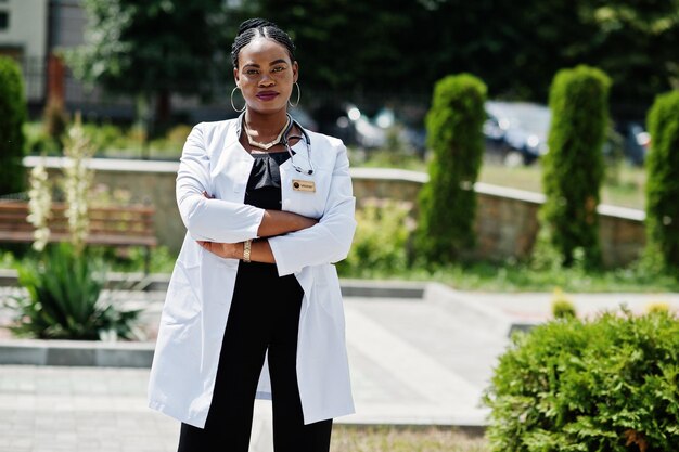 Doctora afroamericana en bata de laboratorio con estetoscopio al aire libre
