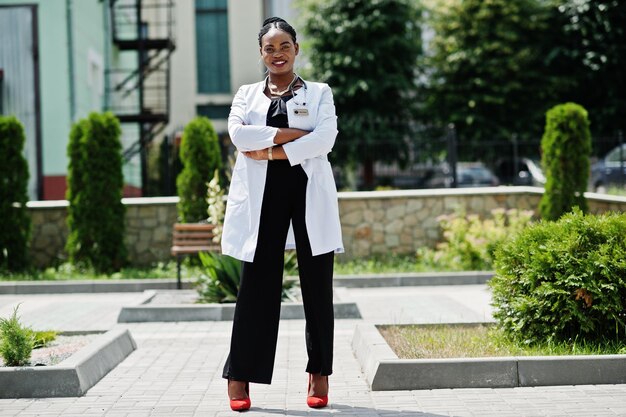 Doctora afroamericana en bata de laboratorio con estetoscopio al aire libre