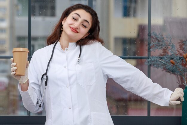 Doctora alegre disfrutando de su freno de café Foto de alta calidad