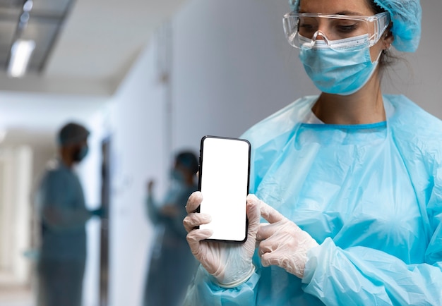 Doctora apuntando a un teléfono inteligente