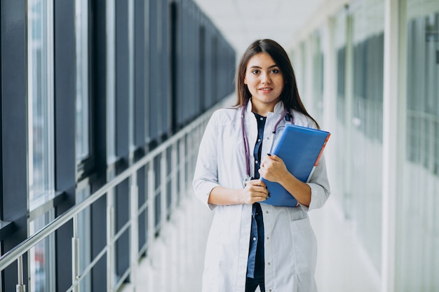 Doctora atractiva de pie con documentos en el hospital