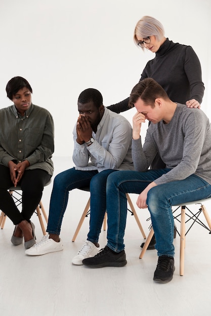 Foto gratuita doctora consolando a hombres tristes