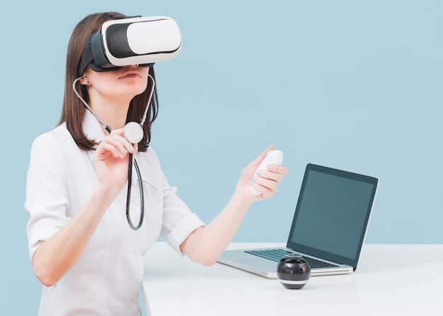 Doctora con estetoscopio y casco de realidad virtual