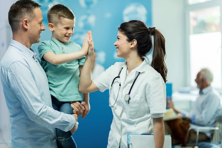 Foto gratuito doctora feliz dando alta fie a un niño que vino con su padre al hospital