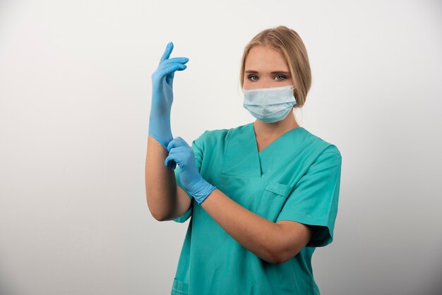 Doctora con guantes de látex y mascarilla médica.