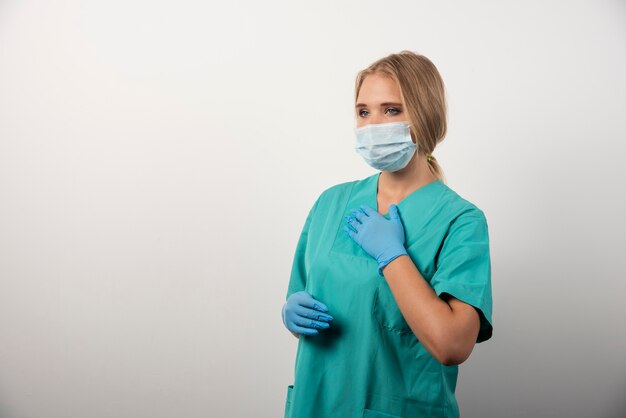 Doctora con guantes de látex y mascarilla médica.