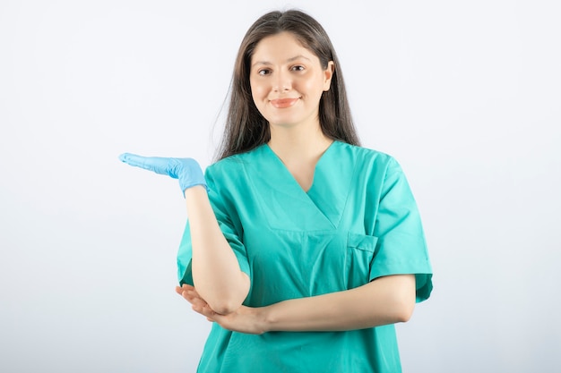 Doctora en guantes médicos mostrando las manos en blanco.