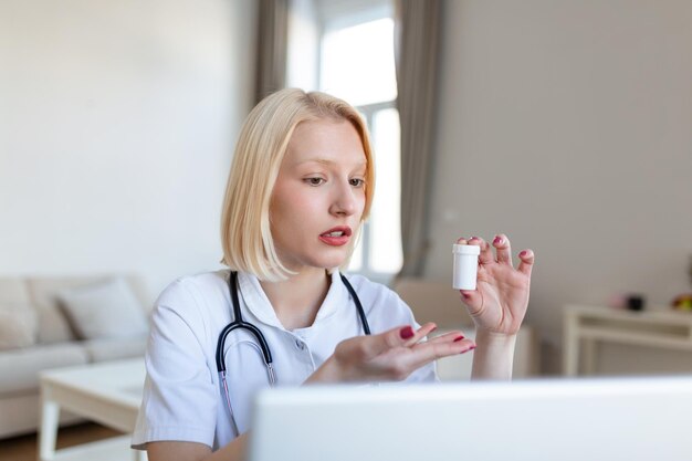 Doctora hablando mientras explica el tratamiento médico al paciente a través de una videollamada con una computadora portátil en la consulta