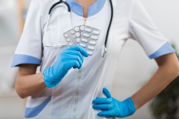 Doctora manos sosteniendo pastillas