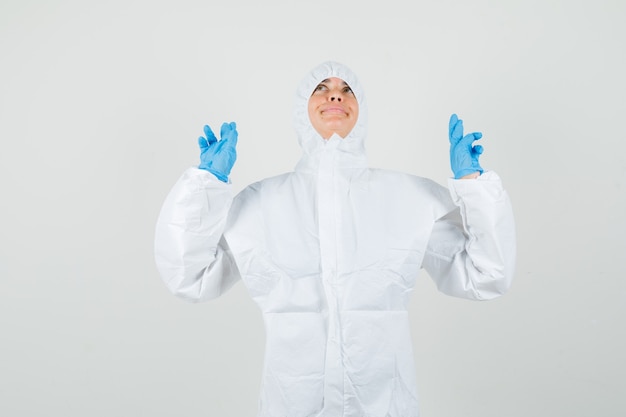 Foto gratuita doctora manteniendo los dedos cruzados en traje protector