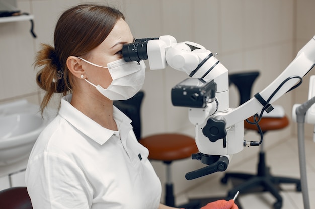 Doctora en máscara médica. El doctor realiza un examen.La mujer realiza un estudio microbiológico