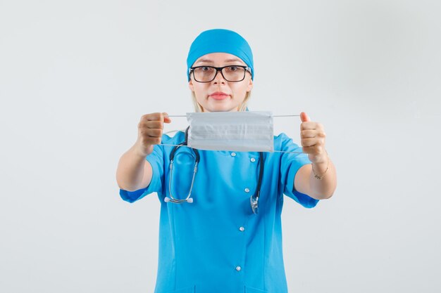 Doctora con máscara médica en uniforme azul