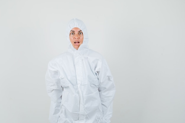 Doctora mirando a la cámara en traje de protección y mirando consternado