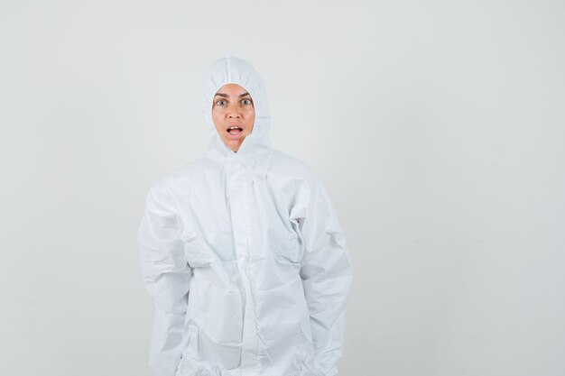 Doctora mirando a la cámara en traje de protección y mirando consternado