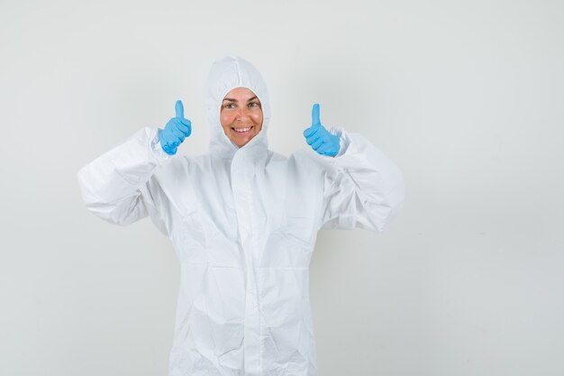 Doctora mostrando doble pulgar hacia arriba en traje protector