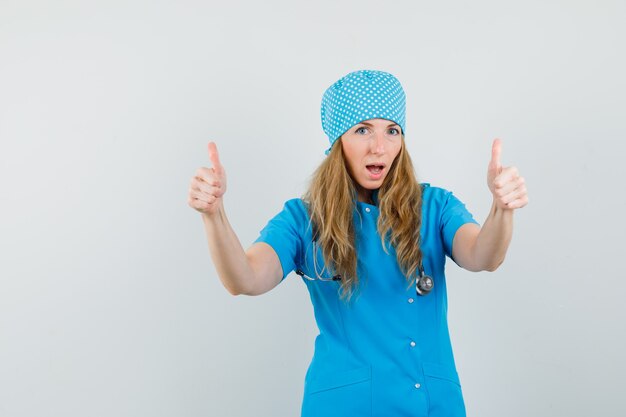 Doctora mostrando doble pulgar hacia arriba en uniforme azul