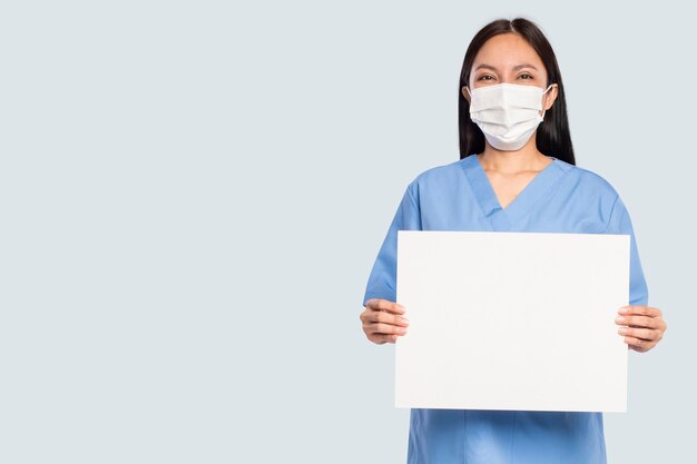 Doctora mostrando un letrero en blanco