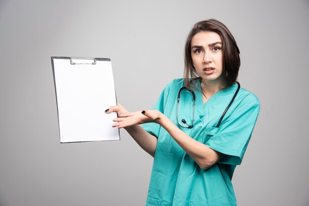 Doctora mostrando portapapeles y preguntando por los resultados. Foto de alta calidad