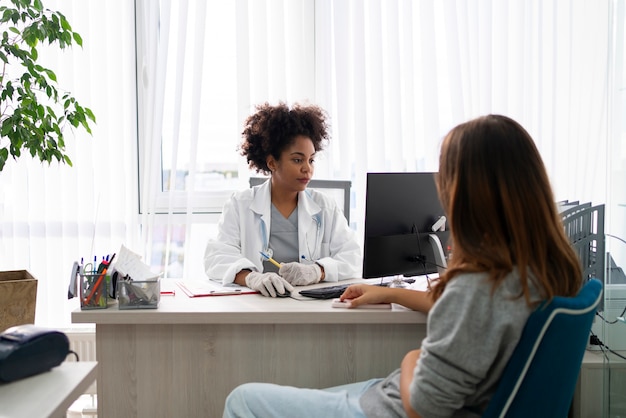 Doctora y paciente de tiro medio