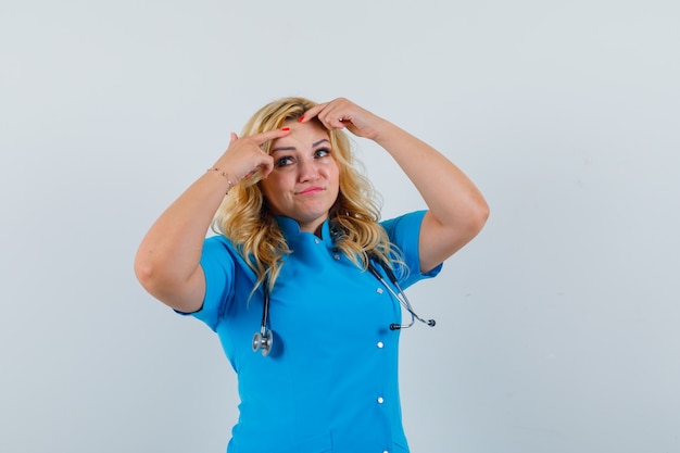 Doctora pellizcando sus espinillas en uniforme azul