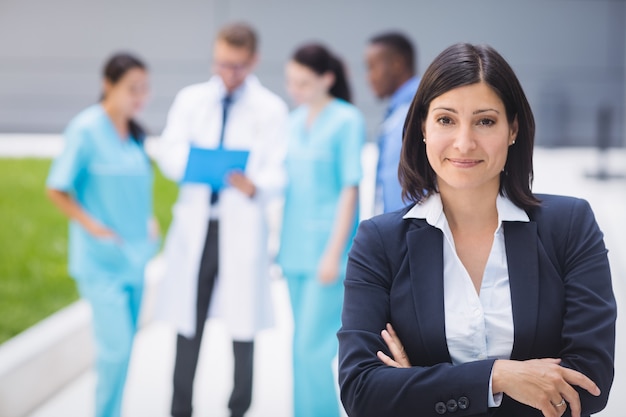 Foto gratuita doctora de pie con los brazos cruzados