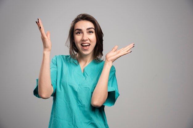 Doctora riendo sobre fondo gris. Foto de alta calidad