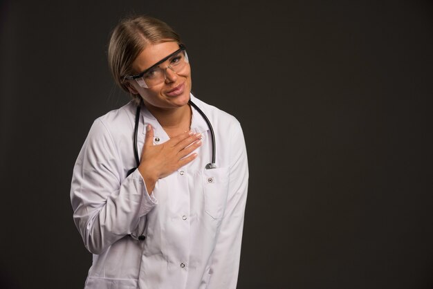 Doctora rubia con un estetoscopio usando anteojos gracias a alguien.