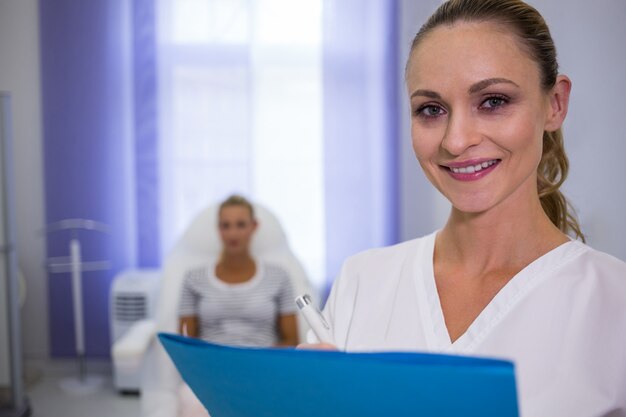 Doctora sonriente con informes médicos