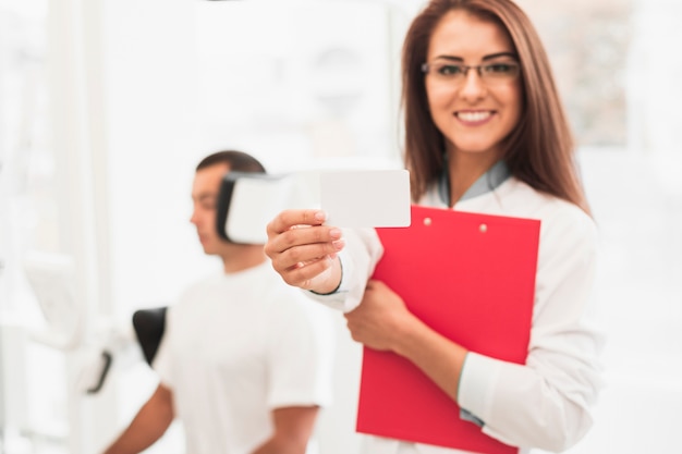 Doctora sonriente mostrando tarjeta simulacro