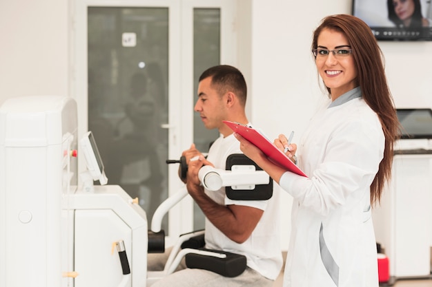 Foto gratuita doctora sonriente que controla la condición del paciente