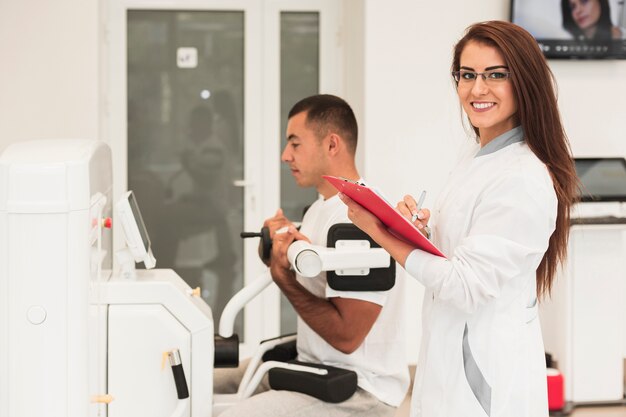 Doctora sonriente que controla la condición del paciente