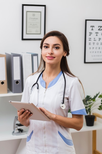 Doctora sonriente sosteniendo una carpeta