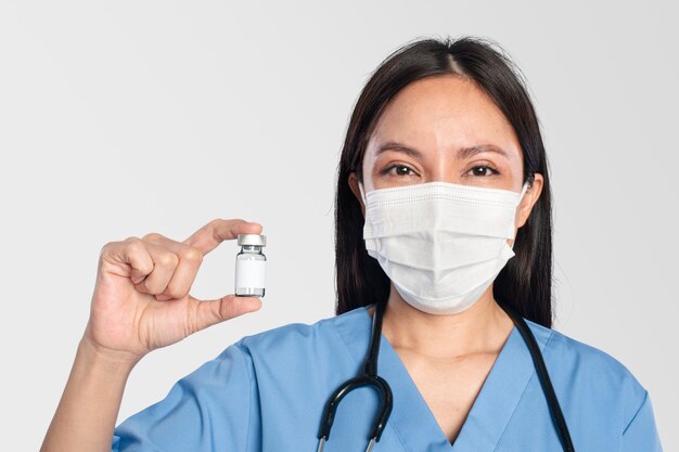 Doctora sosteniendo una botella de vacuna