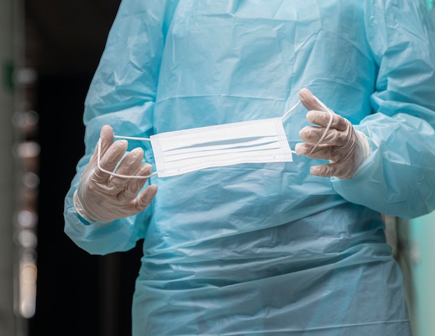 Doctora sosteniendo una mascarilla