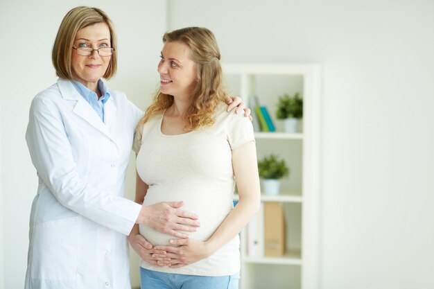 Doctora tocando la barriga de su paciente