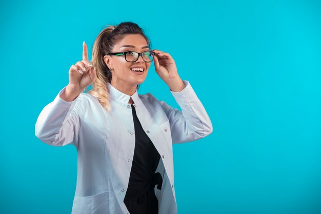 Doctora en uniforme blanco pidiendo atención.