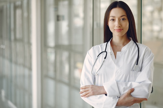 Doctora en uniforme blanco de pie en una sala