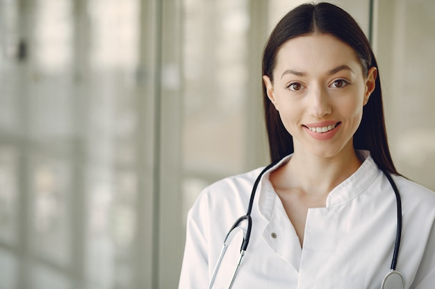 Doctora en uniforme blanco de pie en una sala