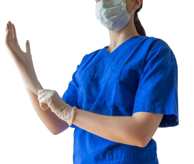 Doctora en uniforme médico y máscara poniéndose guantes médicos preparándose para una cirugía