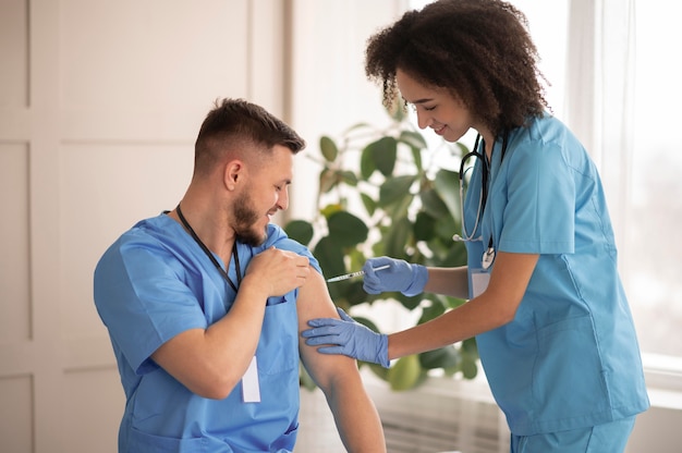 Doctora vacunando a su colega