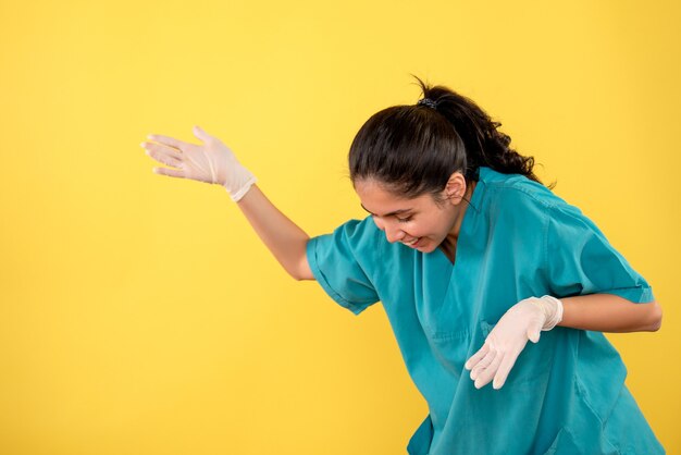 Doctora vista frontal con guantes de látex mirando hacia abajo