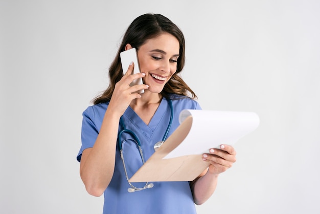 Doctores discutiendo algunos registros médicos por teléfono.