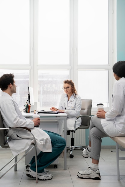 Doctores discutiendo en el trabajo con tazas de café