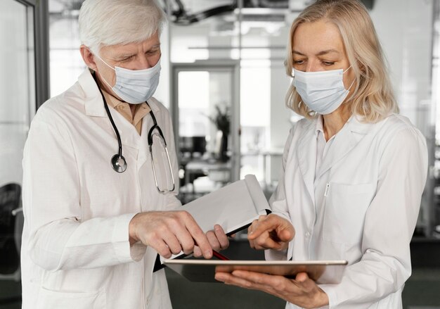 Doctores con máscaras médicas hablando