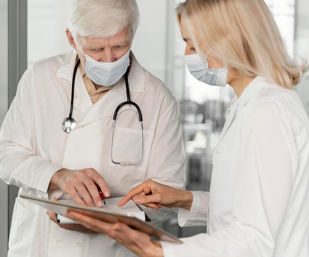 Doctores con máscaras médicas hablando