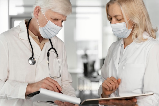 Doctores con máscaras médicas hablando