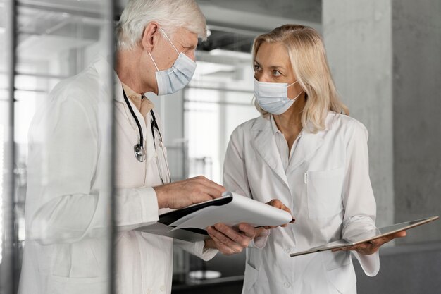Doctores con máscaras médicas hablando