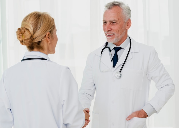 Doctores sonriendo y dándose la mano